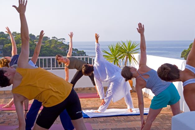 Yogaklasse auf Terrasse am Meer